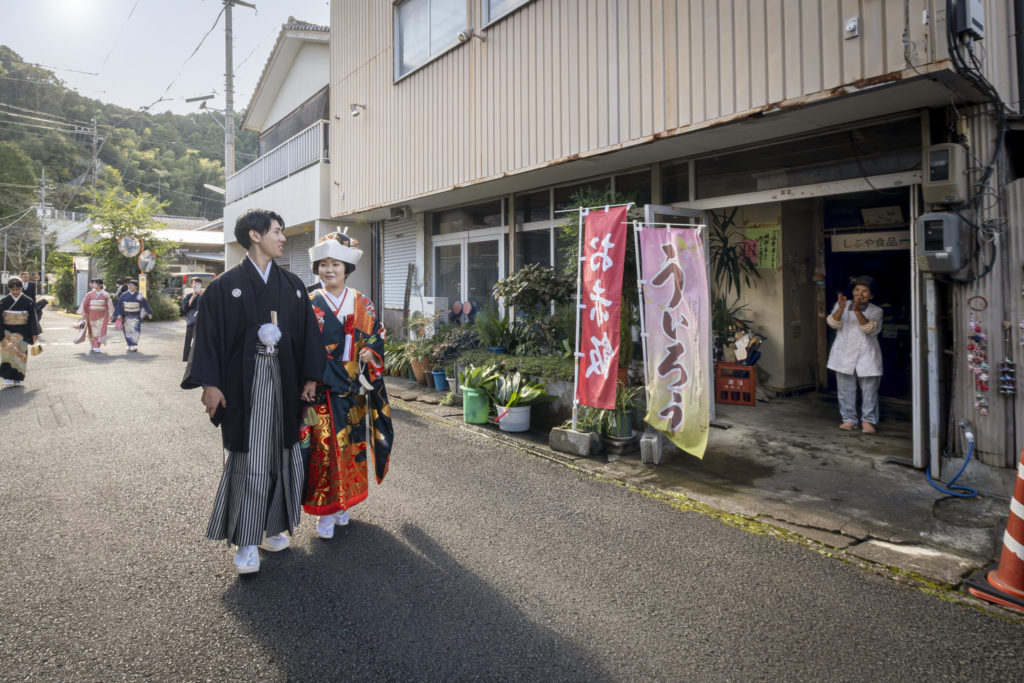 和装の新郎新婦様がご近所の方に祝福される様子