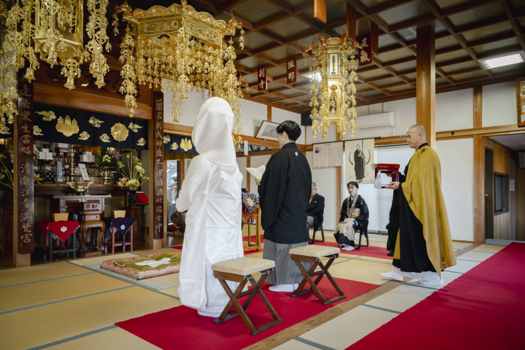江音寺本堂内で御本尊前に立つ新郎新婦様と僧侶の仏前式